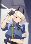  1girl absurdres armband black_gloves blue_archive blurry blurry_foreground blush breasts commentary_request gloves hair_between_eyes hat highres looking_away medium_breasts medium_hair nurse_cap portrait sena_(blue_archive) shadow silver_hair solo wall yellow_eyes yuki_hishaku 
