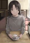  1girl absurdres black_hair brown_eyes brown_sweater closed_mouth commentary cup curtains day english_commentary head_tilt highres indoors light_smile long_hair long_sleeves looking_at_viewer mk_taso original saucer sitting solo sweater teacup 