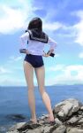  1girl ass bare_legs barefoot black_hair blue_sky blue_swimsuit clouds cloudy_sky day from_behind full_body highres hiki_niito long_hair long_legs long_sleeves ocean one-piece_swimsuit original outdoors sailor_collar sailor_shirt shirt sky solo standing swimsuit thighs white_shirt 