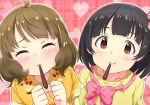  2girls ahoge black_hair blush bow brown_hair clenched_hands closed_eyes collarbone commentary_request dannd dress embarrassed eyebrows_visible_through_hair floral_print food heart highres idolmaster idolmaster_million_live! looking_at_viewer multiple_girls nakatani_iku pink_background pink_bow pocky pocky_in_mouth shirt short_hair short_sleeves suou_momoko wavy_hair yellow_dress yellow_shirt 