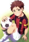  1boy absurdres ball character_request commentary_request copyright_request crossed_legs day green_eyes highres holding holding_ball kanamaru_yuuki looking_at_viewer male_focus outdoors redhead short_hair shorts shou_oota soccer_ball solo teeth uniform victory_kickoff!! 