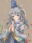  1girl 80isiiii bangs blue_headwear brown_background eyebrows_visible_through_hair grey_eyes grey_hair grin hat highres long_hair long_sleeves looking_at_viewer mononobe_no_futo own_hands_clasped own_hands_together pom_pom_(clothes) ponytail ribbon-trimmed_sleeves ribbon_trim simple_background smile solo tate_eboshi touhou upper_body wide_sleeves 