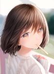  1girl bangs blurry blurry_background brown_eyes brown_hair eyebrows_visible_through_hair hair_between_eyes highres long_sleeves looking_at_viewer looking_back ojay_tkym original outdoors popsicle_stick revision short_hair signature sleeves_past_wrists solo sweater white_sweater 