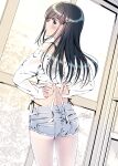  1girl adjusting_clothes ass back bare_shoulders black_hair blue_eyes bra_strap bra_visible_through_clothes branch commentary_request cowboy_shot denim denim_shorts facing_away flower hair_flower hair_ornament hairclip highres kobayashi_chisato long_hair long_sleeves looking_at_viewer midriff original panty_straps shirt short_shorts shorts solo strapless strapless_shirt sunlight tan tanlines thighs tree tying window 