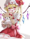  1girl blonde_hair blush bow crystal eyebrows_visible_through_hair fang flandre_scarlet hair_between_eyes happy hat hat_bow heart highres holding holding_stuffed_toy long_hair looking_at_viewer mob_cap open_mouth petticoat pointy_ears puffy_sleeves red_bow red_eyes red_skirt red_vest shinonome_(ichigotsuki) shirt sitting skin_fang skirt solo stuffed_animal stuffed_toy teddy_bear touhou vest wariza white_headwear white_shirt wings 