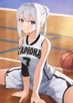  1girl bare_shoulders basketball basketball_uniform between_legs blue_eyes blush commentary_request feet_out_of_frame hair_between_eyes hair_bun hand_between_legs highres long_hair looking_at_viewer original shorts sidelocks silver_hair sitting sleeveless solo sportswear spread_legs tapioka_(oekakitapioka) 