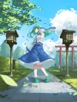 1girl arm_up bangs blue_skirt breasts closed_mouth commentary_request detached_sleeves doitsuudon frog_hair_ornament full_body green_eyes green_footwear green_hair hair_ornament highres kochiya_sanae large_breasts long_hair long_skirt long_sleeves looking_at_viewer nontraditional_miko print_skirt shirt skirt sleeveless sleeveless_shirt snake_hair_ornament solo standing torii touhou wide_sleeves wind