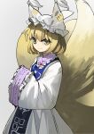  1girl bangs blonde_hair blue_tabard commentary dress fox_girl fox_tail frilled_shirt_collar frilled_sleeves frills grey_background hat highres kitsune kyuubi long_sleeves looking_at_viewer multiple_tails own_hands_together pillow_hat short_hair sideways_glance sleeves_past_fingers sleeves_past_wrists smile suna_(s73d) tail tassel touhou white_dress wide_sleeves yakumo_ran yellow_eyes 