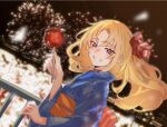  1girl alternate_costume azur_lane bangs blonde_hair blue_kimono blurry blurry_background blush bokeh bu4321 candy_apple cleveland_(azur_lane) depth_of_field fireworks floating_hair food grin hair_down hand_up highres holding holding_food japanese_clothes kimono long_hair looking_at_viewer night obi outdoors parted_bangs red_eyes sash smile solo teeth upper_body yukata 