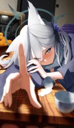  1girl absurdres alternate_costume animal_ear_fluff animal_ears arm_on_table blue_archive blue_eyes blurry blurry_foreground broken_halo choko_(cup) closed_mouth commentary cup depth_of_field eyes_visible_through_hair flower food fruit fur_collar green_halo grey_hair hair_flower hair_ornament halo head_rest highres index_finger_raised indoors japanese_clothes kimono kotatsu looking_at_viewer mandarin_orange migeru690 mismatched_pupils purple_flower purple_kimono shiroko_terror_(blue_archive) smile solo spill table wolf_ears wolf_girl 