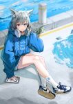  1girl absurdres alternate_costume animal_ear_fluff animal_ears bangs blue_archive blue_hoodie blurry blurry_background cat_ears cellphone cross_hair_ornament full_body grey_hair hair_ornament halo headphones headphones_around_neck highres hood hoodie kinking knee_up long_sleeves looking_at_viewer open_mouth phone puddle shiroko_(blue_archive) shoes sitting smartphone sneakers socks solo water white_legwear 