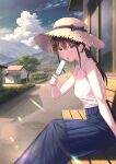  1girl :o bangs bare_shoulders bench blue_eyes blue_skirt brown_hair building clouds cloudy_sky food frilled_shirt frills hand_up hat highres holding holding_food koh_rd long_hair long_skirt looking_at_viewer mountain open_mouth original outdoors ponytail popsicle shirt sitting skirt sky sleeveless sleeveless_shirt solo straw_hat sun_hat tree white_shirt 