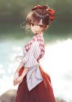  1girl :o absurdres bangs blurry blurry_background bokeh bow brown_eyes brown_hair checkered_clothes commentary cowboy_shot dabo_(parksh5054) day depth_of_field hair_between_eyes hair_bow hair_bun hakama hakama_skirt highres japanese_clothes looking_at_viewer miko original outdoors own_hands_together red_bow red_hakama sidelocks skirt solo striped teeth upper_teeth vertical_stripes 
