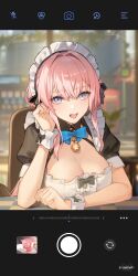 1girl :d aether_gazer bell bell_collar black_bow blue_bow blue_eyes blurry_background blush bow cleavage detached_collar elbow_rest eyebrows_visible_through_hair frills hair_intakes hand_up highres looking_at_viewer maid maid_headdress mole mole_under_eye official_art photo pink_hair puffy_short_sleeves puffy_sleeves short_sleeves sitting taking_picture teeth wadjet_(aether_gazer)