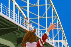  4girls absurdres against_railing animal_ears blonde_hair blue_sky bow bridge brown_hair clothes_around_waist ear_ornament from_behind green_hair hand_up highres horse_ears horse_girl horse_tail jacket jacket_around_waist layered_sleeves long_hair long_sleeves multicolored_hair multiple_girls open_mouth pineconete pink_bow ponytail railing red_track_suit short_over_long_sleeves short_sleeves sirius_symboli_(casual)_(umamusume) sirius_symboli_(umamusume) sky sleeves_rolled_up streaked_hair tail tokai_teio_(umamusume) towel towel_around_neck tracen_training_uniform track_suit umamusume very_long_hair waving white_streaks 