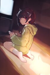  1girl ahoge blunt_bangs blurry blurry_background blush brown_hair chinese_commentary closed_mouth commentary controller dot_mouth drawstring dutch_angle eyelashes from_behind from_side game_controller green_hoodie highres holding holding_controller holding_game_controller hood hood_down hoodie jitome kienlg68 looking_at_viewer looking_back looking_to_the_side no_shoes on_floor playing_games playing_video_games red_eyes sitting socks solo sweatdrop television touhoku_kiritan twintails voiceroid wariza white_socks 