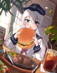  1girl anchor_symbol black_headwear black_sailor_collar blue_eyes burger commentary_request drink eating flat_cap food hat hibiki_(kancolle) highres indoors kantai_collection long_hair neckerchief o-sirius red_neckerchief sailor_collar school_uniform serafuku solo steak upper_body white_hair window 