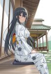  1girl banned_artist black_hair blue_sky clouds commentary_request cushion day feet_out_of_frame highres house icomochi japanese_clothes kimono leaf_print long_hair looking_at_viewer original outdoors sitting sky smile solo veranda white_kimono yukata zabuton 