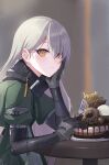  1girl bangs black_gloves blurry blurry_background cake candy character_name chocolate chocolate_bar closed_mouth dessert doughnut elbow_rest food fork girls_frontline gloves green_jacket hair_behind_ear hair_between_eyes happy_birthday head_on_hand head_rest highres holding jacket long_hair long_sleeves looking_at_viewer mg4_(girls&#039;_frontline) ranyu sitting solo table truffle upper_body yellow_eyes 