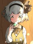  1girl bangs black_bow black_bowtie black_hairband blush bow bow_hairband bowtie breasts closed_mouth collared_shirt commentary_request dango food green_eyes green_vest grey_hair hairband hitodama_print holding holding_food kometani0829 konpaku_youmu looking_at_viewer shirt short_hair small_breasts smile solo touhou upper_body vest wagashi white_shirt 