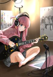  1girl bangs blue_eyes bocchi_the_rock! closed_mouth computer gotou_hitori grey_skirt guitar hair_between_eyes headphones highres holding holding_instrument indoors instrument jacket jersey laptop light long_sleeves medium_hair microphone music pink_hair pink_jacket playing_instrument pleated_skirt poster_(object) school_uniform sitting skirt smile soragane_(banisinngurei) track_jacket track_suit 