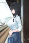  bag black_hair blouse blurry blurry_background blush breasts brown_eyes collared_shirt highres holding holding_bag kinokkoooo large_breasts long_hair original pleated_skirt school_uniform shirt shirt_tucked_in skirt solo standing tented_shirt train_station white_shirt 