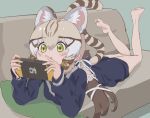  1girl animal_ears bare_legs barefoot blonde_hair blue_sweater blush bow brown_hair cat_ears cat_girl cat_tail commentary extra_ears geoffroy&#039;s_cat_(kemono_friends) green_eyes hair_bow kemono_friends kemono_friends_v_project kunikuni_(kunihiro2005) long_hair long_sleeves lying multicolored_hair nintendo_switch on_stomach sailor_collar school_uniform sidelocks solo sweater symbol-only_commentary tail the_pose twintails white_bow 