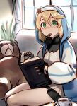  1girl akisa_yositake androgyne_symbol bangs black_gloves black_skirt blonde_hair blue_hoodie blush book bridget_(guilty_gear) commentary_request cookie couch cup dress fingerless_gloves food gloves green_eyes guilty_gear guilty_gear_strive hair_between_eyes holding holding_book hood hood_up hoodie indoors long_sleeves looking_at_viewer mouth_hold on_couch open_book puffy_long_sleeves puffy_sleeves roger_(guilty_gear) seiza sitting skirt solo stuffed_animal stuffed_toy teacup teddy_bear transgender twitter_username yellow_dress 