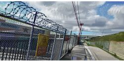  barbed_wire blue_sky chain-link_fence clouds cloudy_sky day fence highres lamppost nate_d_hernandez no_humans original outdoors power_lines puddle sign sky utility_pole warning_sign 