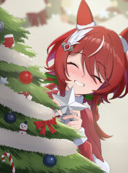  1girl absurdres animal_ears blush capelet christmas christmas_ornaments christmas_tree closed_eyes commentary_request dress ear_covers ear_ornament feather_hair_ornament feathers fur-trimmed_capelet fur_trim grin hair_between_eyes hair_ornament highres holding horse_ears horse_girl long_hair looking_at_viewer mugi_mg317 open_mouth red_capelet red_dress red_hair santa_costume santa_dress smile solo textless_version twintails umamusume win_variation_(umamusume) 