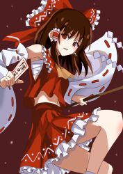  1girl ascot between_fingers bow breasts brown_hair chest_sarashi commentary detached_sleeves frilled_bow frilled_hair_tubes frilled_skirt frills gohei hair_bow hair_tubes hakurei_reimu holding holding_gohei holding_ofuda long_hair looking_at_viewer ofuda ofuda_between_fingers red_background red_bow red_eyes red_skirt ribbon-trimmed_sleeves ribbon_trim sarashi simple_background skirt skirt_set small_breasts solo touhou veow yellow_ascot 