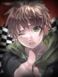  1boy absurdres black_jacket blurry blurry_background brown_hair checkered_background d; danganronpa:_trigger_happy_havoc danganronpa_(series) green_eyes green_hoodie highres hollowgeek hood hood_down hoodie jacket lower_teeth_only male_focus naegi_makoto one_eye_closed open_clothes open_jacket pointing pointing_at_viewer short_hair solo teeth tongue 