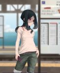  1girl alternate_costume belt black_hair blurry blurry_background capri_pants cellphone commentary_request contrapposto cowboy_shot grey_pants hair_over_shoulder highres kantai_collection kumano_maru_(kancolle) long_hair looking_to_the_side neko_no_hige pants phone red_eyes shirt solo train_station white_shirt 