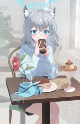 1girl absurdres animal_ears aworuw1137 blue_archive blue_eyes blue_halo blue_scarf blurry blurry_background coffee cross cross_hair_ornament dessert flower food grey_hair hair_ornament halo highres inverted_cross mismatched_pupils scarf shiroko_(blue_archive) skirt sweater table wolf_ears wooden_table 