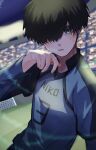  1boy black_hair blue_eyes blue_lock blue_shirt blurry blurry_background cowboy_shot domenica_mpana hair_over_one_eye hand_up highres long_sleeves looking_at_viewer male_focus niko_ikki shirt short_hair soccer_uniform solo sportswear standing sweat 