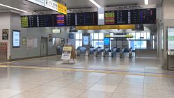  commentary_request concrete fare_gate folding_sign glass_door hamachi_no_senaka_(buri_no_nitsuke) highres indoors no_humans original reflective_floor scenery shadow tile_floor tiles trash_can window 