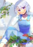  1girl blurry blurry_background blurry_foreground closed_mouth collarbone commentary_request commission depth_of_field feet_out_of_frame grey_hair hair_between_eyes hand_up head_tilt knees_up kou_hiyoyo long_sleeves looking_at_viewer original overalls plant potted_plant puffy_long_sleeves puffy_sleeves shirt short_hair skeb_commission smile solo violet_eyes white_shirt 