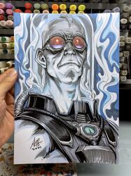  1boy armor art_tools_in_frame artist's_hand_in_frame aura batman_(series) closed_mouth commentary dc_comics english_commentary fishbowl_helmet highres male_focus marker_(medium) mr._freeze photo_(medium) power_armor red_goggles short_hair solo stanley_lau traditional_media tube upper_body very_short_hair 