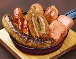  brown_background food food_focus frying_pan highres meat no_humans original sausage tainosuke wood 