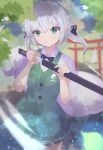  1girl alternate_hairstyle black_bow black_bowtie blurry blurry_background bow bowtie closed_mouth collared_shirt commentary_request cowboy_shot ghost green_eyes green_skirt green_vest grey_hair highres holding holding_sword holding_weapon konpaku_youmu konpaku_youmu_(ghost) long_hair looking_at_viewer low_twintails matcha_yado outdoors sheath shirt short_sleeves skirt solo standing sword torii touhou twintails unsheathing vest weapon white_shirt 
