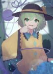  1girl black_headwear blurry blurry_background commentary_request finger_to_mouth green_eyes green_hair hat hat_ribbon heart heart_of_string highres komeiji_koishi light_particles long_sleeves looking_at_viewer matcha_yado open_mouth ribbon shirt short_hair solo third_eye touhou upper_body wide_sleeves yellow_ribbon yellow_shirt 
