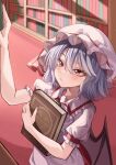  1girl bat_wings book bookshelf closed_mouth commentary_request hat hat_ribbon highres holding holding_book indoors maboroshi_mochi mob_cap pink_headwear purple_hair red_eyes red_ribbon remilia_scarlet ribbon short_hair short_sleeves solo touhou upper_body wings 