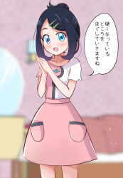  1girl :d black_hair blue_eyes blurry blurry_background blush collarbone commentary_request cosplay cowboy_shot dress eyelashes hair_bun hair_ornament hairclip hands_up indoors joy_(pokemon) joy_(pokemon)_(cosplay) liko_(pokemon) medium_hair mitumi_mira open_mouth own_hands_together palms_together pokemon pokemon_(anime) pokemon_horizons short_sleeves smile solo speech_bubble translation_request 