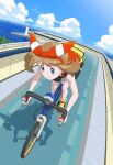  1girl bent_over bicycle bike_shorts bow_hairband brown_hair closed_mouth clouds commentary day eyelashes fanny_pack grey_eyes hairband highres holding ia_(ilwmael9) latias latios lighthouse may_(pokemon) ocean outdoors pokemon pokemon_(game) pokemon_oras riding riding_bicycle shirt shoes sky sleeveless sleeveless_shirt smile split_mouth water yellow_bag yellow_footwear 