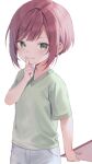  1girl closed_mouth commentary_request finger_to_mouth green_eyes green_shirt hand_up holding looking_at_viewer midorikawa_you mole mole_under_eye original pants redhead shirt short_hair short_sleeves shushing sidelocks simple_background smile solo standing white_background white_pants 