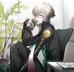  1boy absurdres asclepius_(fate) bishounen black_jacket black_pants clipboard crossed_bangs cup drinking eyelashes fate/grand_order fate_(series) green_eyes grey_hair grin highres holding holding_cup indoors jacket long_arms long_hair long_sleeves male_focus mug pants plant ponytail potted_plant sitting smile solo table very_long_hair zuraa_(naunau_seijin) 