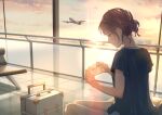  1girl absurdres aircraft airplane blue_shirt brown_hair closed_mouth clouds commentary_request feet_out_of_frame grey_eyes hair_bun highres holding indoors macaronk original pants profile shirt short_sleeves sitting sky smile suitcase sunset white_pants window 