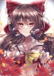  1girl ascot blurry blurry_foreground bow brown_hair collarbone commentary hair_bow hair_tubes hakurei_reimu highres leaf long_hair looking_at_viewer maple_leaf mashiropuni midriff parted_lips red_bow red_eyes solo touhou upper_body yellow_ascot 