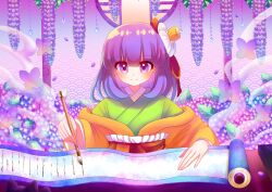  1girl absurdres blush breasts calligraphy_brush closed_mouth commentary_request falling_petals flower flower_request green_kimono hair_flower hair_ornament hieda_no_akyuu highres holding holding_calligraphy_brush holding_paintbrush japanese_clothes kimono long_hair long_sleeves paintbrush petals purple_flower purple_hair purple_petals scroll small_breasts smile solo table touhou user_ghaf3443 violet_eyes white_flower writing yellow_kimono 