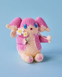  :o amigurumi_(medium) asako_ito audino blue_background flower full_body highres holding holding_flower no_humans official_art open_mouth photo_(medium) pokemon pokemon_(creature) pokemon_focus pokemon_tcg second-party_source shadow simple_background solo unconventional_media white_flower 
